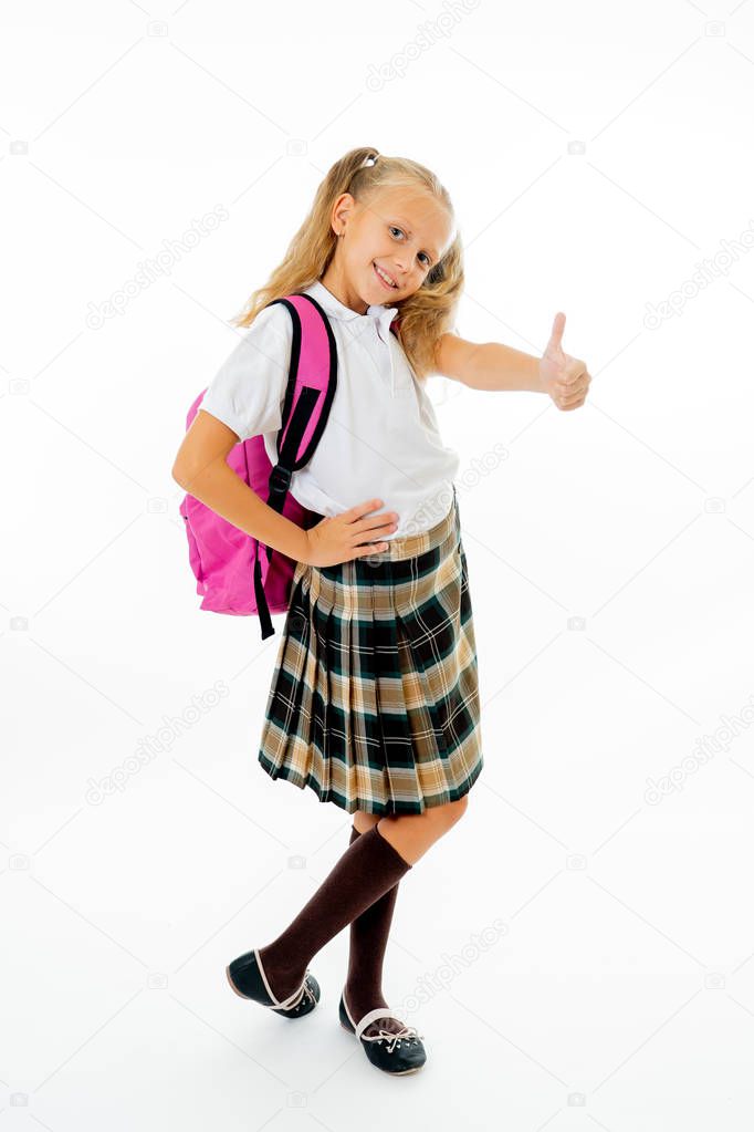 Pretty cute blonde hair girl with a pink schoolbag looking at camera showing thumb up gesture happy to go to school isolated on white background in back to school and children education concept