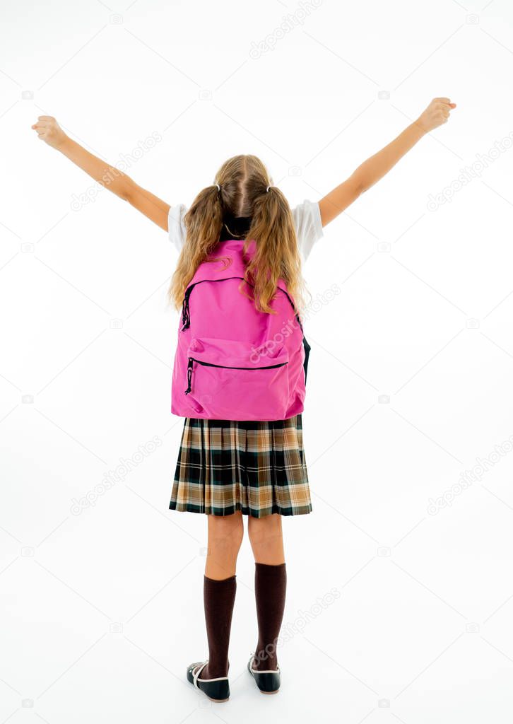 Beautiful blonde haired girl in uniform carrying a big pink schoolbag with raised hands isolated on white background