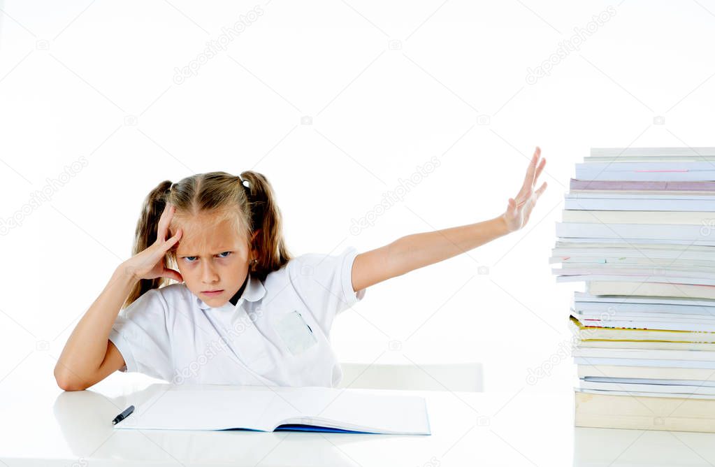 Sad and tired cute schoolgirl with blonde hair sitting in stress doing homework. overwhelm with too much study and textbooks. Children education academic performance and school systems concept