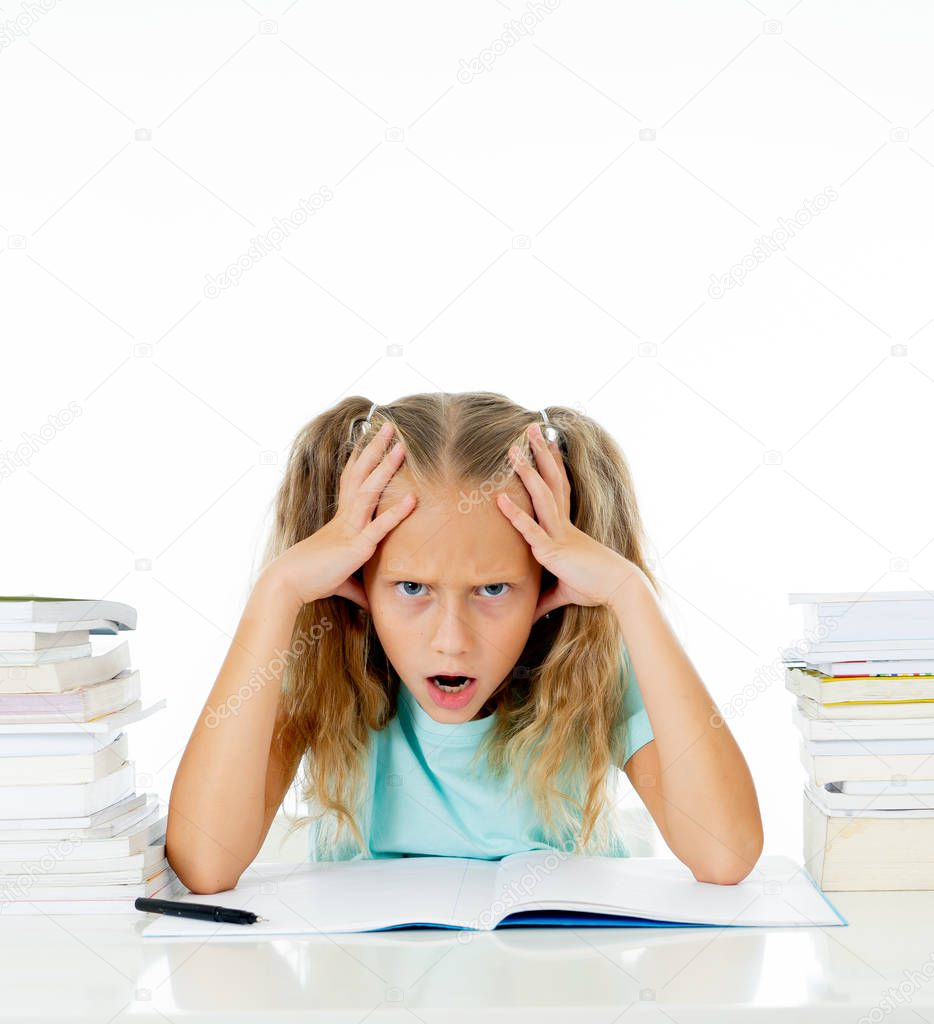 Angry little girl with a negative attitude towards studies and school after studying too much and having too many homework isolated on a white background. Children education concept