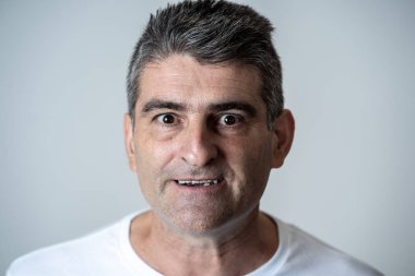 Bir öfkeli seyir olgun 40'lı 50'li beyaz kızgın ve üzgündüm ve agresif insan duyguları yüz ifadeleri ve duyguları kavramı üzerinde gri arka plan izole portresi.