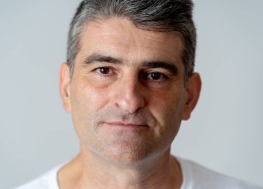 Tarafsız bakan çekici olgun birisi portre rahat ve yüz ifadeleri insan duygular içinde ciddi gri mavi arka plan üzerinde izole.