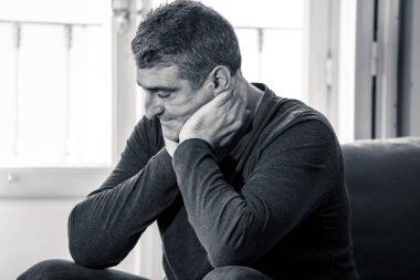 Çekici bir adam duygu umutsuz üzgün endişeli bakarak düşünceli ve yalnız orta yaş krizi ruhsal kişisel sorunlar ve yaşam tarzı kavramı evde kanepede depresyon acı depresif.