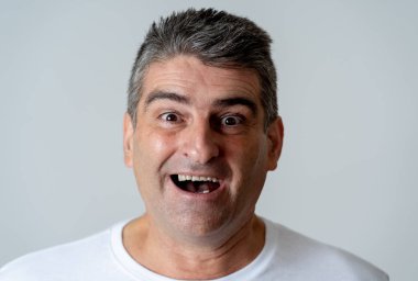 Adam onun hedefi ulaşmada piyango yeme sevinmektedir veya büyük bir başarı olan yüz ifade insan duyguları şaşırttı ve mutlu yüz ifadesi gri arka plan üzerinde izole.