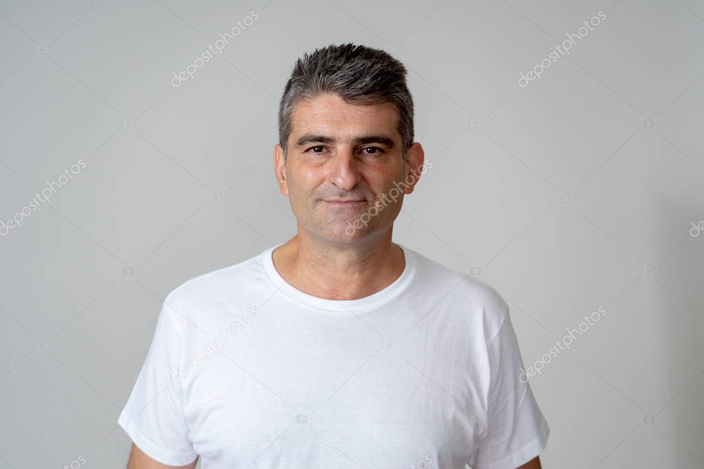 Portrait of a attractive mature man looking neutral relaxed and serious in facial expressions human emotions isolated on grey blue background.