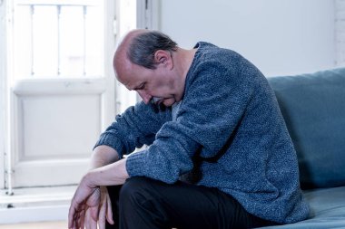 Bunalmış eski üst düzey adam yalnız ev hissi acı eskime emeklilik dul demans ve Alzheimer kavram evde kanepede yalnız üzücü şaşkın.