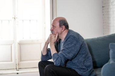 Bunalmış eski üst düzey adam yalnız ev hissi acı eskime emeklilik dul demans ve Alzheimer kavram evde kanepede yalnız üzücü şaşkın.