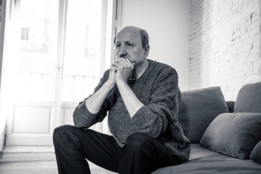 Kıdemli yaşlı adam umutsuz üzgün endişeli bakarak duygu düşünceli ve yalnız evde kanepede yaşlanma zihinsel sağlık kişisel sorunlar ve yaşam tarzı kavramı depresif.