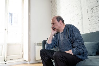 Bunalmış eski üst düzey adam yalnız ev hissi acı eskime emeklilik dul demans ve Alzheimer kavram evde kanepede yalnız üzücü şaşkın.