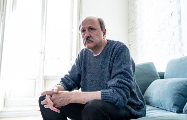 Bunalmış eski üst düzey adam yalnız ev hissi acı eskime emeklilik dul demans ve Alzheimer kavram evde kanepede yalnız üzücü şaşkın.