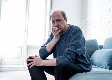 Bunalmış eski üst düzey adam yalnız ev hissi acı eskime emeklilik dul demans ve Alzheimer kavram evde kanepede yalnız üzücü şaşkın.