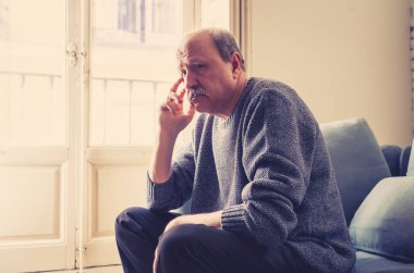 Kıdemli yaşlı adam umutsuz üzgün endişeli bakarak duygu düşünceli ve yalnız evde kanepede yaşlanma zihinsel sağlık kişisel sorunlar ve yaşam tarzı kavramı depresif.