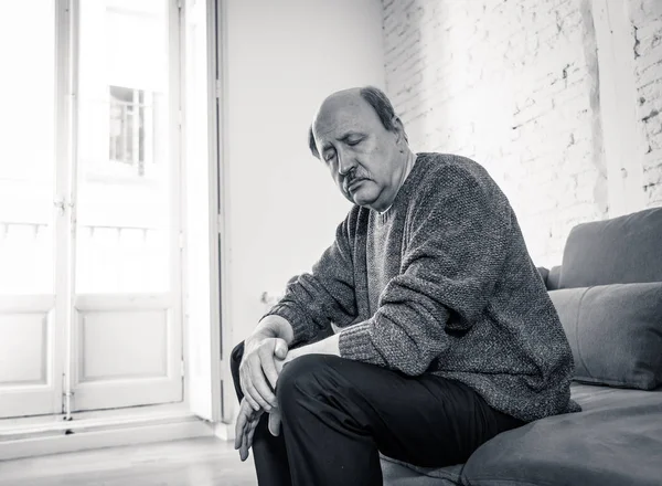 Bunalmış eski üst düzey adam yalnız ev hissi acı eskime emeklilik dul demans ve Alzheimer kavram evde kanepede yalnız üzücü şaşkın.
