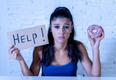 Genç latin kadın cazip ve çikolata yemek isteyen suçlu hissediyorum endişeli ve donut isteyen diyet kalori şeker bağımlılığı beslenme ve yaşam tarzı kavramı içinde yardım.