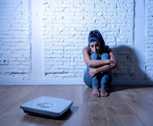 一人で心配して失敗したダイエットと栄養障害概念を食べることで落ち込んでスケールを見て地面に座って拒食症過食症 代の若い女性 — ストック写真