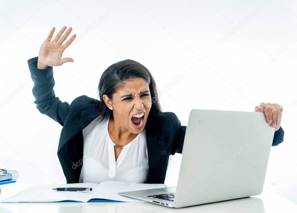 Angry furious stressed and overworked businesswoman yelling at her laptop in crisis lifestyle and long hours of work concept isolated on white background