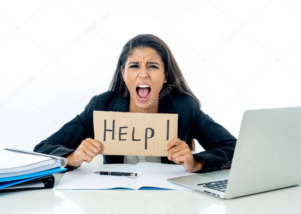Young attractive businesswoman working on computer laptop suffering stress at office going crazy holding a help sign