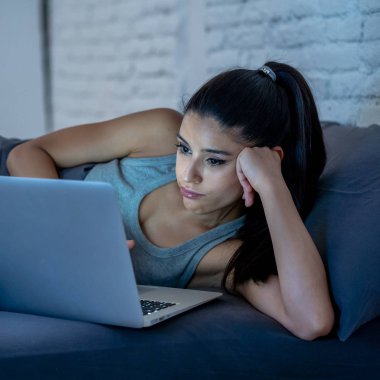 Çalışma ve internet bağımlılığı ve aşırı iş yükü kavram gece geç saatlerde bilgisayar evde kanepede ile internette sörf yorgun çekici genç kadın.