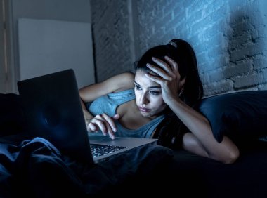 Çalışma ve internet bağımlılığı ve aşırı iş yükü kavram gece geç saatlerde bilgisayar evde kanepede ile internette sörf yorgun çekici genç kadın.