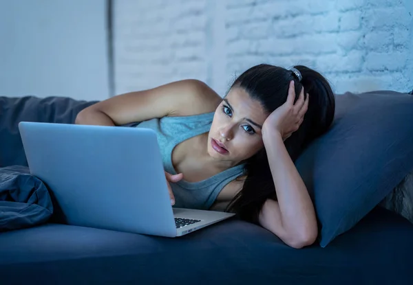 疲れの魅力的な若い女性 インターネット中毒と過労の概念で夜遅く自宅のソファの上のコンピューターとインターネット上のサーフィン — ストック写真