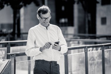 İhtiyar kalmak bağlı sosyal ağ modern teknolojiyi kullanarak cep telefonuna metin iletileri gönderip onun 60s içinde mutlu yakışıklı ve girişimci yaratıcı iş kavramı.
