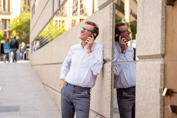 Красивий Зрілий Креативний Позаштатний Бізнесмен Розмовляє Мобільному Телефоні Посміхається Спираючись — стокове фото