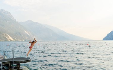 Çekici kadın eğleniyor lago di garda İtalya için suya atlama yaz tatil eğlenceli tatil seyahat Avrupa.