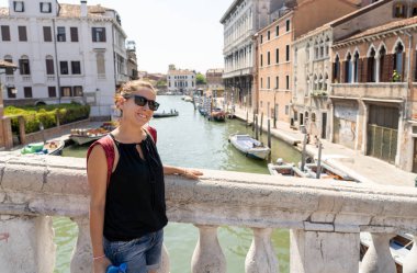 Poz ve yaz tatil seyahat Venedik kanalda Europe kavramı etrafında, güneş gözlüklü kameraya bakarak çekici doğal latin turist kadın.