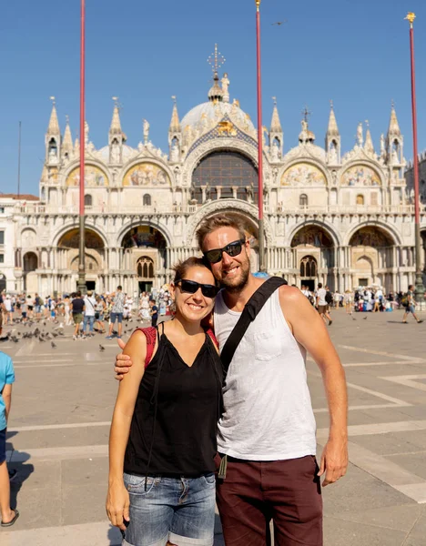 Happy couple taking a selfie with smart mobile phone in the canals of Venice the famous european city in Italy in summer holidays Tourism Traveling around europe vacation love and honeymoon concept.