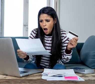 Vergi ve muhasebe banka ödemeleri ve aile içi bütçe içinde ipotek kredi kartı hesap makinesi maliyetlerle dizüstü kullanarak internet bankacılığı üzerinden online fatura ödeme endişeli çaresiz kadın ücretleri