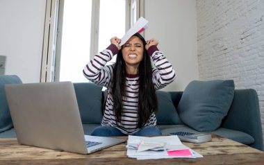 Vergi ve muhasebe banka ödemeleri ve aile içi bütçe içinde ipotek kredi kartı hesap makinesi maliyetlerle dizüstü kullanarak internet bankacılığı üzerinden online fatura ödeme endişeli çaresiz kadın ücretleri