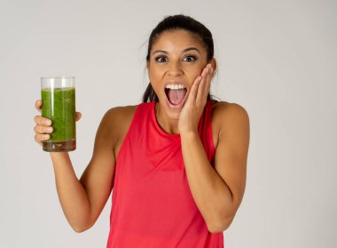 Kadın fitness fitness egzersiz Güzellik Sağlık Fitness diyet beslenme ve sağlıklı yaşam konsepti gri arka plan üzerinde izole çalıştıran sonra holding cam yeşil sebze güler yüzlü gülen mutlu.