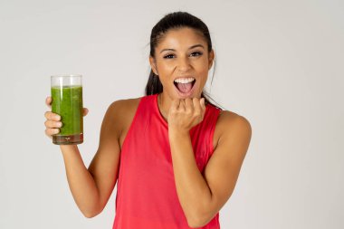 Kadın fitness fitness egzersiz Güzellik Sağlık Fitness diyet beslenme ve sağlıklı yaşam konsepti gri arka plan üzerinde izole çalıştıran sonra holding cam yeşil sebze güler yüzlü gülen mutlu.