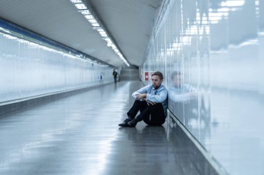 Genç işsiz iş adam oturan depresyon acı duvar yalnız duygusal acı ruh sağlığı işsizlik ve insan duyguları kavramı umutsuz seyir üzerinde Sokak Metro yaslanmış zemin.