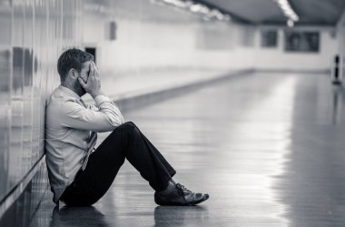 Genç işsiz iş adam oturan depresyon acı duvar yalnız duygusal acı ruh sağlığı işsizlik ve insan duyguları kavramı umutsuz seyir üzerinde Sokak Metro yaslanmış zemin.