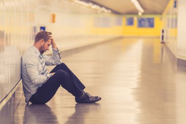 Genç işsiz iş adam oturan depresyon acı duvar yalnız duygusal acı ruh sağlığı işsizlik ve insan duyguları kavramı umutsuz seyir üzerinde Sokak Metro yaslanmış zemin.