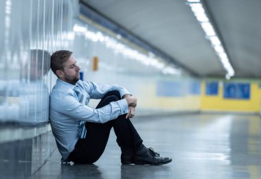 Genç işsiz iş adam oturan depresyon acı duvar yalnız duygusal acı ruh sağlığı işsizlik ve insan duyguları kavramı umutsuz seyir üzerinde Sokak Metro yaslanmış zemin.