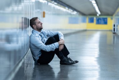Genç işsiz iş adam oturan depresyon acı duvar yalnız duygusal acı ruh sağlığı işsizlik ve insan duyguları kavramı umutsuz seyir üzerinde Sokak Metro yaslanmış zemin.