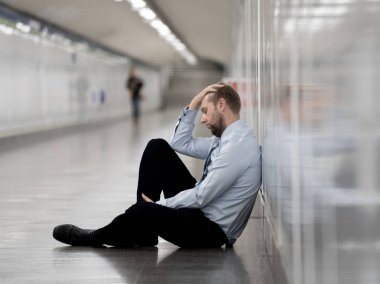 Genç işsiz iş adam oturan depresyon acı duvar yalnız duygusal acı ruh sağlığı işsizlik ve insan duyguları kavramı umutsuz seyir üzerinde Sokak Metro yaslanmış zemin.