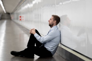 Genç işsiz iş adam oturan depresyon acı duvar yalnız duygusal acı ruh sağlığı işsizlik ve insan duyguları kavramı umutsuz seyir üzerinde Sokak Metro yaslanmış zemin.