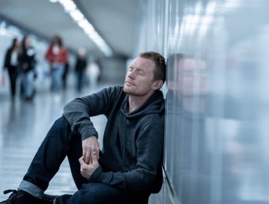 Sefil işsiz genç adam ağlayan uyuşturucu bağımlısı evsizlere depresyon stres zemin sokak Metro'ya ruhsal bozukluk duygusal acı üzüntü yalnız duvara yaslanmış umutsuz seyir üzerinde oturan.