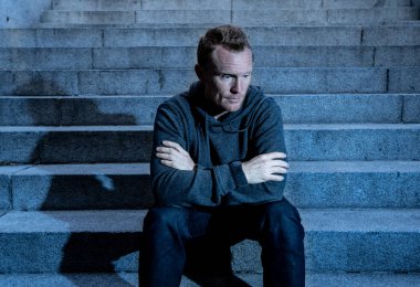 Lost ın depresyon zemin beton merdiven duygusal acı yalnızlık üzüntü zihinsel sağlık kavramı grunge aydınlatmada yalnız oturan genç umutsuz işsiz adam rahat kıyafetler içinde terk.
