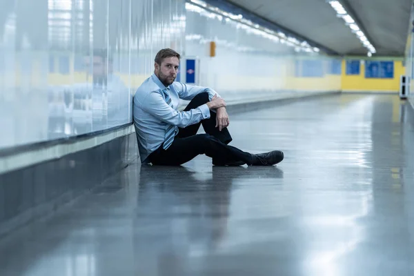年轻的失业商人遭受抑郁症坐在地下靠墙独自看着绝望的情绪疼痛心理健康失业与人的情感观念 — 图库照片