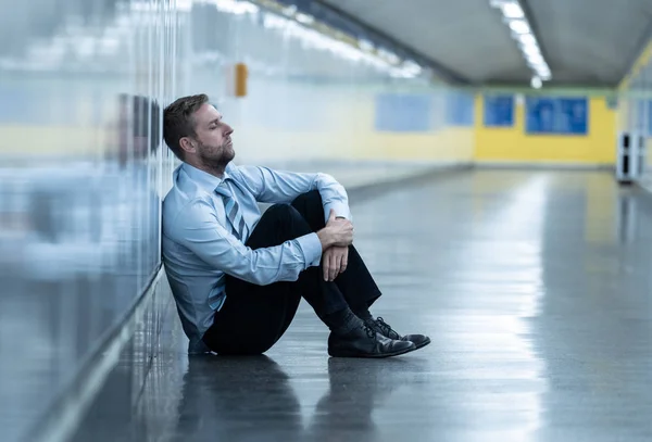 うつの上に座って若い失業者ビジネス男地面壁だけで必死に探して感情的な痛みメンタルヘルス失業と人間の感情概念の通りに地下傾い — ストック写真