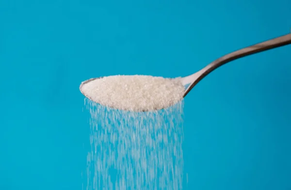 Socker Att Hälla Från Sked Ström Isolerad Blå Bakgrund Alltför — Stockfoto