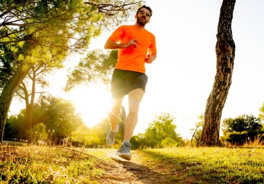 Spor giyim dışında maraton için eğitim Park'ta spor sağlıklı yaşam tarzı ve koşu çapraz ülke eğitim egzersiz açık havada kavramı güzel yaz gününde günbatımında çalışan mutlu runner.