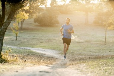 Spor giyim dışında maraton için eğitim Park'ta spor sağlıklı yaşam tarzı ve koşu çapraz ülke eğitim egzersiz açık havada kavramı güzel yaz gününde günbatımında çalışan mutlu runner.