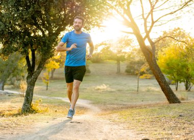 Spor giyim dışında maraton için eğitim Park'ta spor sağlıklı yaşam tarzı ve koşu çapraz ülke eğitim egzersiz açık havada kavramı güzel yaz gününde günbatımında çalışan mutlu runner.
