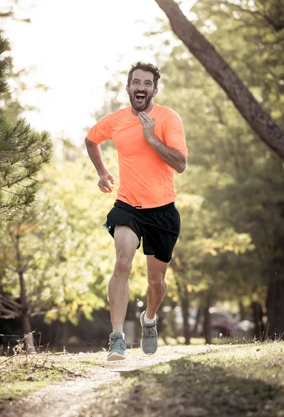 Happy runner in sportswear running training for Marathon outside in park at sunset on beautiful summer day in Sports Healthy lifestyle and Jogging Cross Country Training Workout Outdoors concept.