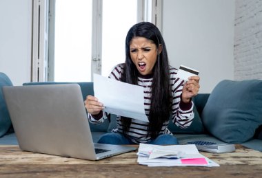 Vergi ve muhasebe banka ödemeleri ve aile içi bütçe içinde ipotek kredi kartı hesap makinesi maliyetlerle dizüstü kullanarak internet bankacılığı üzerinden online fatura ödeme endişeli çaresiz kadın ücretleri